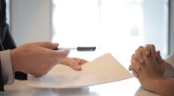 Crop businessman giving contract to woman to sign